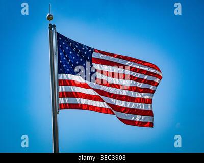 Bandiera americana che sventola su uno sfondo blu del cielo incorniciato da un bagliore bianco Foto Stock