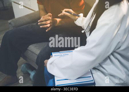 Operatore sanitario che fornisce supporto e assistenza empatica, mettendo delicatamente le mani sul braccio di una donna anziana Foto Stock