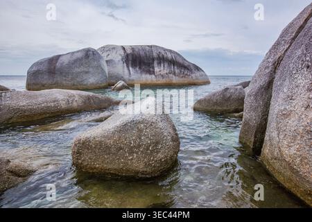 Primo piano di grandi massi di granito sulla spiaggia di Tanjung Tinggi in un giorno coperto, Belitung Island, Indonesia Foto Stock