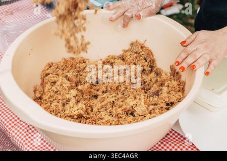 Ciotola del tradizionale Duvan Cvarci serbo ad un festival gastronomico, scaglie di maiale tritate che ricordano la consistenza del tabacco Foto Stock