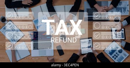 I professionisti si impegnano in una discussione strategica sui rimborsi fiscali, utilizzando laptop, tablet e report di dati per analizzare le informazioni finanziarie in un Foto Stock