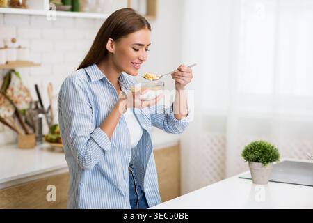Gusta una deliziosa ciotola di yogurt in una Bright Kitchen la mattina soleggiata Foto Stock