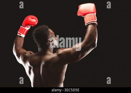 Strong Fighter celebra la vittoria con pugni rialzati in guanti da boxe rossi Foto Stock