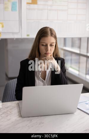 Giovane donna seria, dipendente dell'ufficio che legge ha ricevuto e-mail Foto Stock