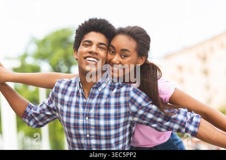 La giovane coppia gode di momenti divertenti nel parco cittadino durante la giornata di sole Foto Stock