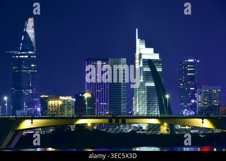 Vibrante vista notturna dello skyline di ho chi Minh con la Bitexco Financial Tower e il Ponte di Thu Thiem, Vietnam Foto Stock