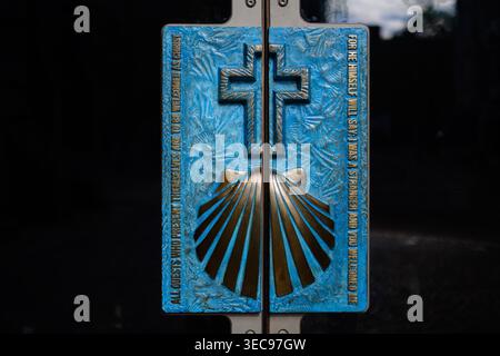 Primo piano dettagliato di una targa blu e di bronzo con motivo a croce e capesante con un'accogliente iscrizione cristiana all'ingresso del CH Foto Stock