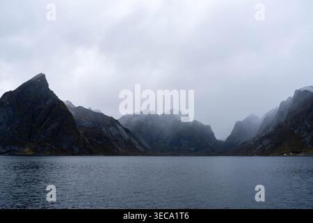 Montagne scure attraverso un fiordo a Moskenesoya, Lofoten, Norvegia Foto Stock