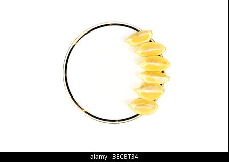 Fette mature di frutta gialla al limone su un piatto fantasioso con spazio di copia Foto Stock