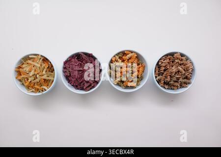 Diversi tipi di pasta in ciotole pronte per la cottura Foto Stock