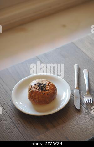Pasticceria appena sfornata su un piatto bianco in un ambiente luminoso Foto Stock