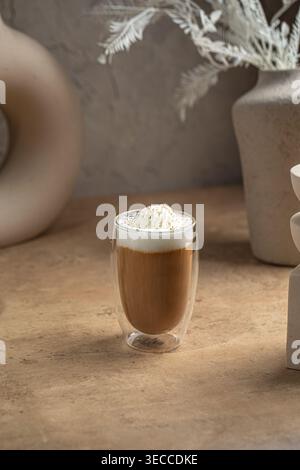 Caffè latte con schiuma in una tazza di vetro Foto Stock