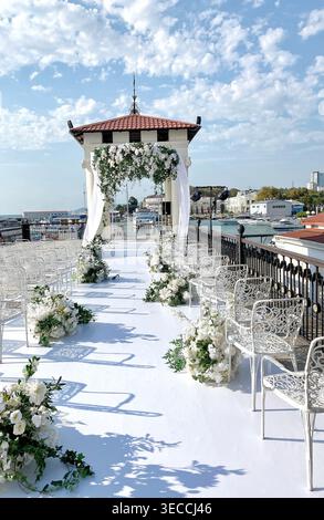 Elegante cerimonia di nozze all'aperto sul mare, luce naturale e atmosfera romantica Foto Stock
