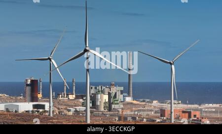 Turbine eoliche che generano energia pulita insieme a una centrale elettrica a ciclo combinato sulla costa di Tenerife, migliorando l'energia verde sostenibile. Shot statico Foto Stock