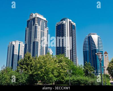 Grozny, Russia - 30 luglio 2021: Il paesaggio urbano delle Torri di Grozny, caratterizzato da grattacieli moderni e da lussureggianti alberi verdi del parco Foto Stock