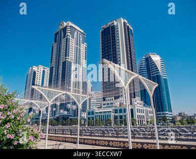 Grozny, Russia - 30 luglio 2021: Moderni grattacieli e archi decorativi sono allineati al paesaggio urbano di Grozny sotto un cielo blu brillante Foto Stock