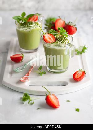Panna cotta di tè verde Matcha con latte di cocco ricoperto di fragola in bicchieri. Concetto di dessert sano senza glutine per l'estate. Foto Stock