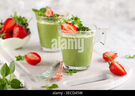 Panna cotta di tè verde Matcha con latte di cocco ricoperto di fragola in bicchieri. Concetto di dessert sano senza glutine per l'estate. Foto Stock