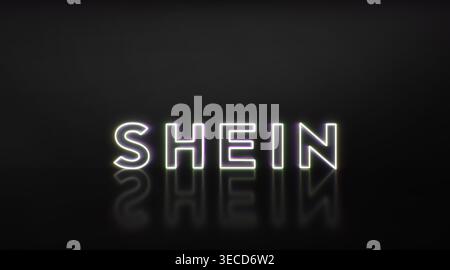 shein illuminato che espone un popolare rivenditore di abbigliamento online, che riflette su una superficie scura e lucida, che rappresenta l'e-commerce e la fast fashion Foto Stock