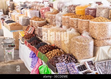 Frutta secca e frutta secca esposte in grandi sacchetti al bazar Siab di Samarcanda. Un'abbondante banchina di mercato con mandorle, pistacchi, datteri e noci, ideale per viaggi e immagini gastronomiche. Foto Stock