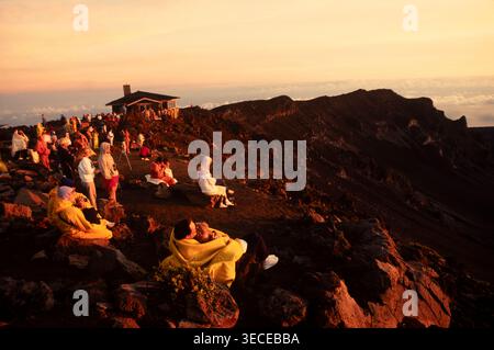 Avventurieri in cima alla montagna Haleakala per l'alba e poi scendi fino al livello del mare in bicicletta, isola di Maui, Hawaii, Stati Uniti Foto Stock
