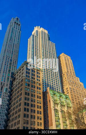 Alti grattacieli si innalzano contro un cielo azzurro limpido a Lower Manhattan, mostrando la splendida architettura e la bellezza urbana della città. Foto Stock