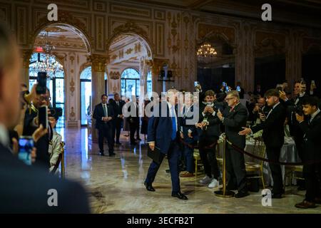 Il presidente Donald J. Trump saluta i partecipanti mentre cammina attraverso una sala interna ornata presso il Mar-a-Lago Club prima di parlare a una conferenza sulla criptovaluta a Palm Beach, Florida, il 25 aprile 2026. Per gentile concessione della Casa Bianca. Foto Stock