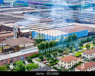 Veduta aerea del complesso industriale e residenziale con filari di case e alberi verdi a Dalmine, Lombardia, Italia. Foto Stock