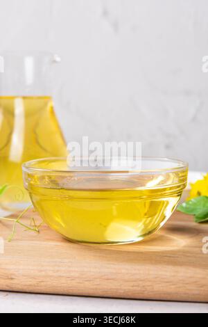 Olio vegetale versato in un piccolo recipiente di vetro per la cottura o l'insalata Foto Stock