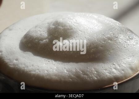 Tazza di caffè con schiuma al caffè locale alla luce del mattino Foto Stock