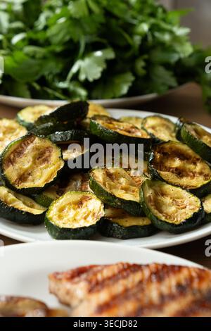 Fette di zucchine grigliate su un piatto da vicino. Foto Stock