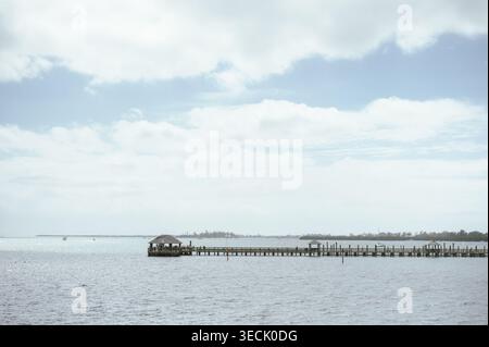 Lungo molo che si estende attraverso la tranquilla baia di Anna Maria Island sotto le nuvole Foto Stock