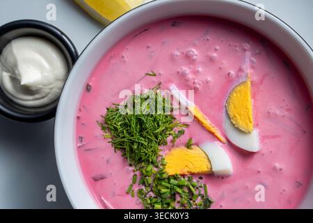 Zuppa di barbabietole fredda dall'angolazione alta con panna acida e limone Foto Stock
