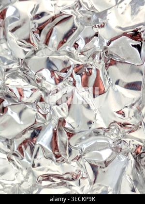Sfondo ravvicinato in foglio di argento astratto lucido e increspato Foto Stock