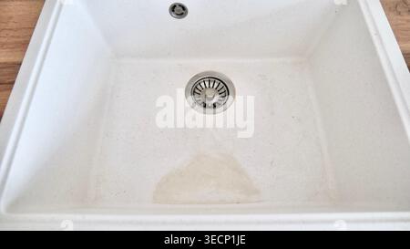 Lavello da cucina in pietra artificiale sporco bianco con scarico in metallo, vista dall'alto Foto Stock