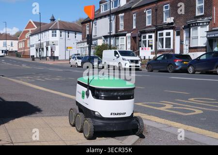Sheffield, Regno Unito - 11 aprile 2026: Robot di consegna autonomo Uber Eats in pausa su un marciapiede accanto alla strada a Woodseats, Sheffield Foto Stock