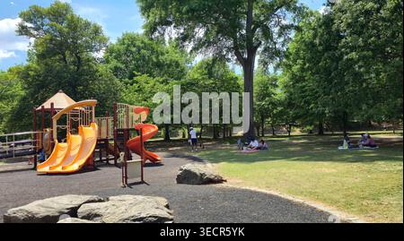 Famiglie che si rilassano e bambini che giocano in un parco giochi del Piedmont Park ad Atlanta, Georgia, USA, in una giornata di sole, mostrando uno stile di vita urbano Foto Stock