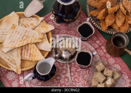 Dolci orientali e caffè sul tavolo. Baklava, halva per dessert. Cibo e bevande. Foto Stock