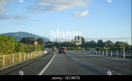 Cartello con il limite di velocità di 110 km/h sulla Kapiti Expressway. Il sole del tardo pomeriggio proietta lunghe ombre sull'autostrada. Nuova Zelanda. Foto Stock