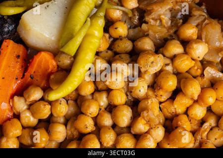 Primo piano del tradizionale cocido spagnolo con ceci teneri, carote vivaci, patate e peperoni saporiti. Una Mediterra sostanziosa e confortante Foto Stock