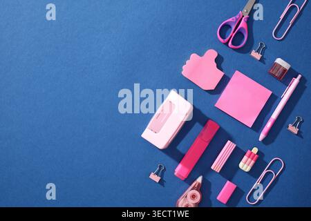 Composizione pop art di materiale scolastico rosa su sfondo blu, tra cui forbici, clip, penne e note; concetto per Back to School for Generation Foto Stock