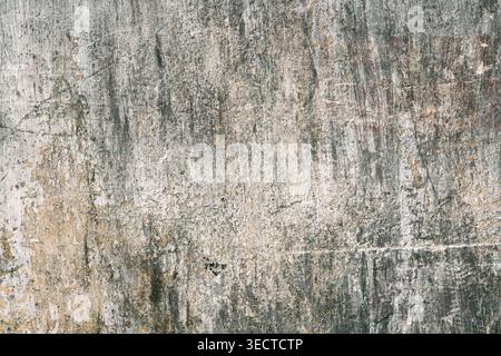 Calcestruzzo verniciato scrostato in stile grunge urbano con sbucciatura superficie unica e morbida della parete con fori, graffi e crepe sullo sfondo macro Foto Stock