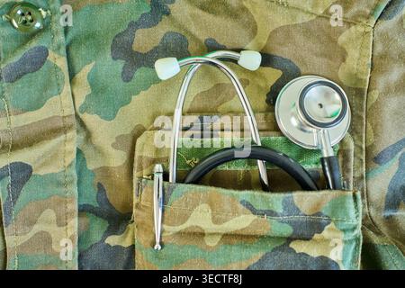Primo piano dello stetoscopio e della penna inMilitary Doctor Robe Pocket. Concetto di Global Healthcare, Medicine and Insurance con spazio di copia. Foto Stock