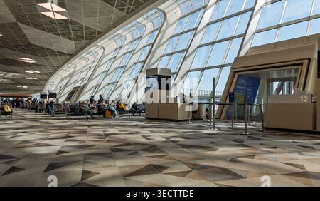All'interno dell'aeroporto internazionale Heydar Aliyev di Baku, Azerbaigian. Passeggeri in attesa in un terminal moderno con un'architettura geometrica unica. Foto Stock