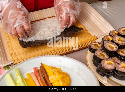 Tradizionale kimbap coreano arrotolato a mano con riso multi-grano e vari ingredienti Foto Stock