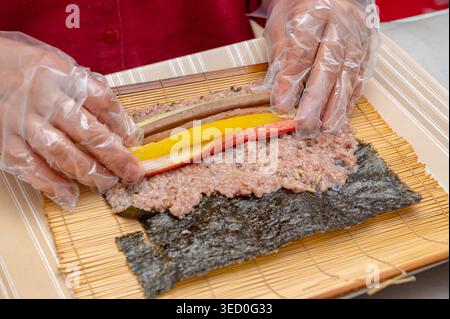Tradizionale kimbap coreano arrotolato a mano con riso multi-grano e vari ingredienti Foto Stock