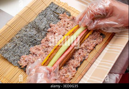 Tradizionale kimbap coreano arrotolato a mano con riso multi-grano e vari ingredienti Foto Stock
