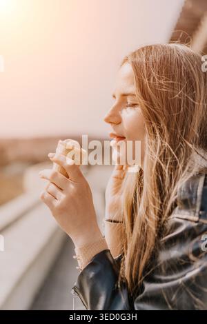 Gelato donna estate giovane donna bionda che si gode un cono di gelato alle fragole all'aperto in una giornata di sole con spazio per le copie Foto Stock