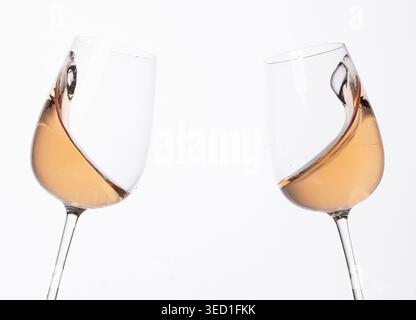 Due bicchieri di vino brindati insieme sullo sfondo bianco. Foto Stock