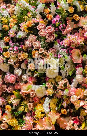Colorata parete floreale con rose e fiori primaverili misti per matrimonio e sfondo decorativo Foto Stock